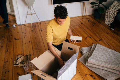 Man packing a moving box.